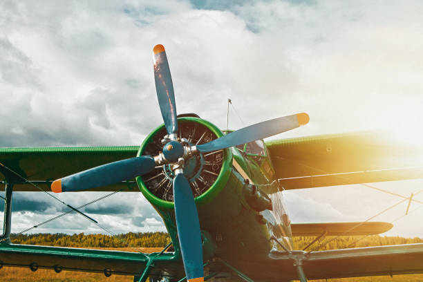Vintage airplane at sunset. Retro plane stands on the landing pad on background of stormy sky. stock photo