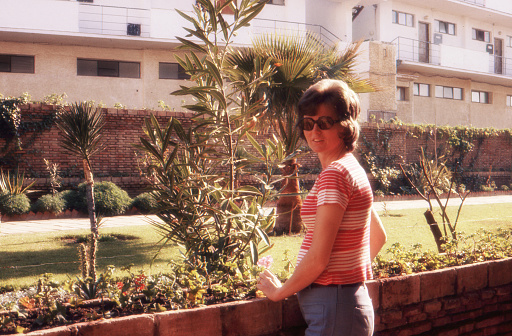 1974 vintage analog image of a young pregnant woman enjoying the sun on her balcony in Torremolinos, Spain.