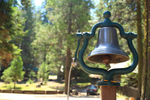 A vintage bell with pine forest in the background stock photo