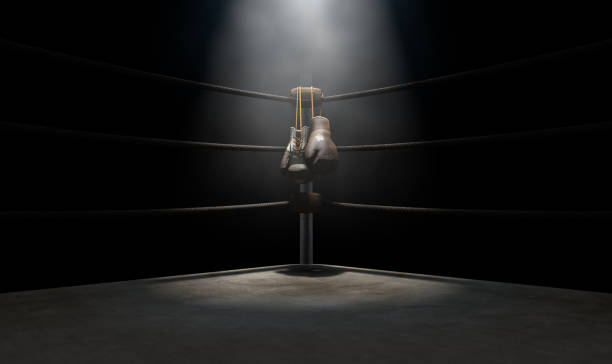 Vintage Boxing  Corner And Hung Up Gloves A closeup of the corner of an old vintage boxing ring surrounded by ropes spotlit by a spotlight on an isolated dark background - 3D render boxing gloves stock pictures, royalty-free photos & images