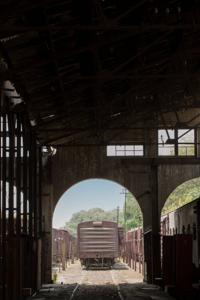 Vintage cargo train showing from an arch at an industrial railway workshop stock photo