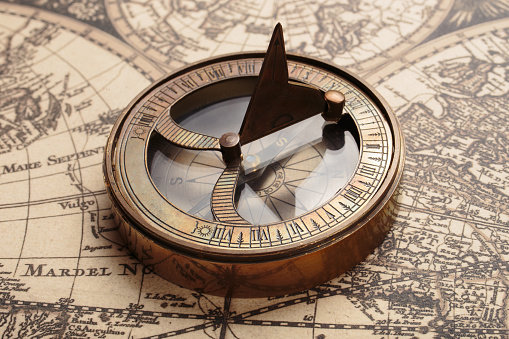 Vintage compass with sundial on old map. Adventure retro style