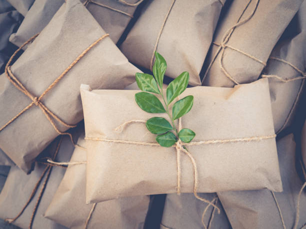 Vintage gift wrapping, tied with rope decorated to look at the green leaves.Tone film stock photo