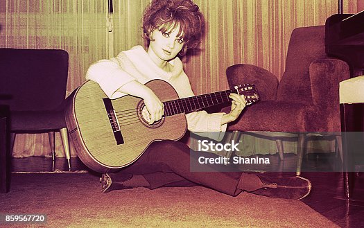 istock Vintage girl playing guitar at home 859567720
