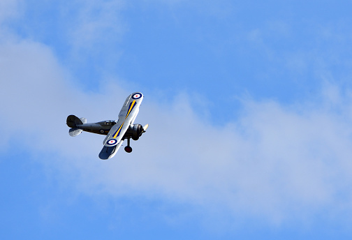 Ickwell, Bedfordshire, England - August 02, 2020: Vintage Gloster Gladiator aircraft in flight with cloud and blue sky