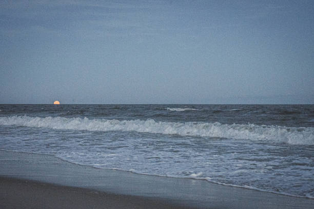 Vintage gray moonrise over rockaway beach stock photo
