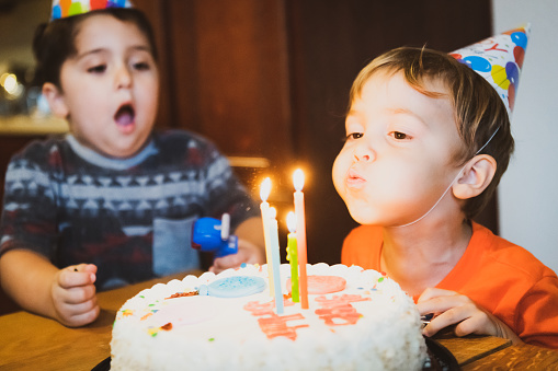 Recreation of a Vintage image from the seventies, children blowing birthday cake candles