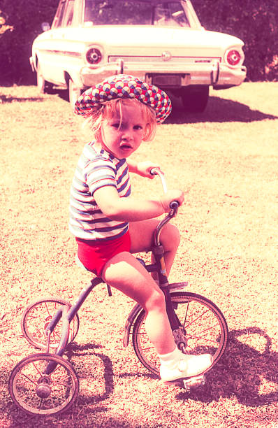 Vintage kid on tricycle Vintage kid riding on a tricycle outdoors. blond hair photos stock pictures, royalty-free photos & images