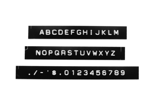 An A-Z, 0-9 vintage label maker font (created with a 1970s style label maker) -- isolated on a white background. Punctuation also included.