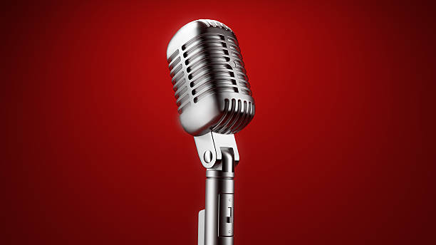 A vintage microphone in front of a red background stock photo