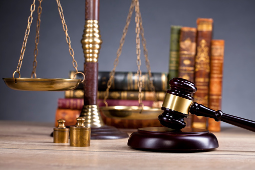 Vintage Office Room In A Law Firm With The Legal Hammer And The Scales Of Justice On The Table With Law Books In The Background Stock Photo - Download Image Now - iStock