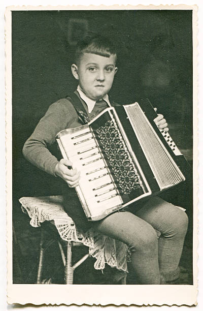 Vintage photo of boy playing an accordion stock photo