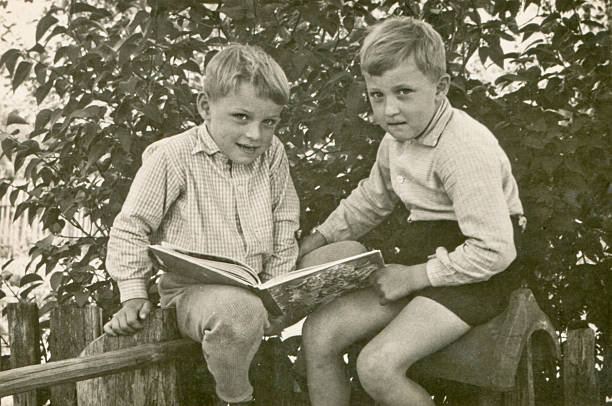 Vintage photo of brothers reading stock photo