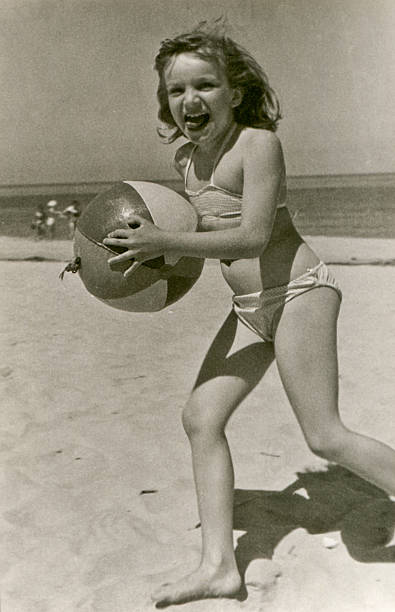 Vintage photo of young girl with a ball on beach stock photo