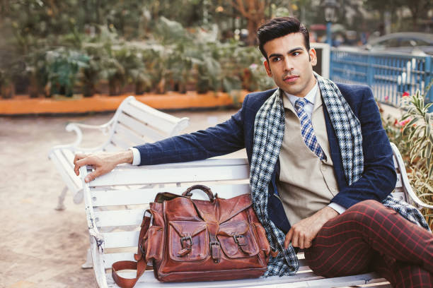 Hipster indio de estilo vintage Hombre indio guapo con bolsas de ropa de negocios vintage fotografías e imágenes de stock