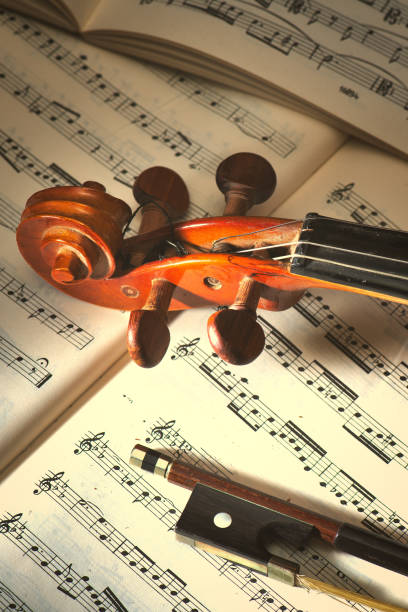 Violin with bow resting on sheet music stock photo