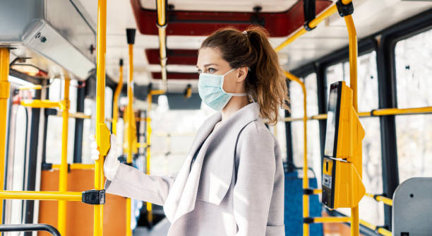 Virus protection in public transportation Woman wearing surgical protective mask going to work bus stock pictures, royalty-free photos & images