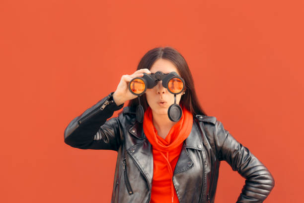 Visionary Millennial Girl Looking through Binoculars Cool woman wearing leather jacket using binocular device chasing stock pictures, royalty-free photos & images