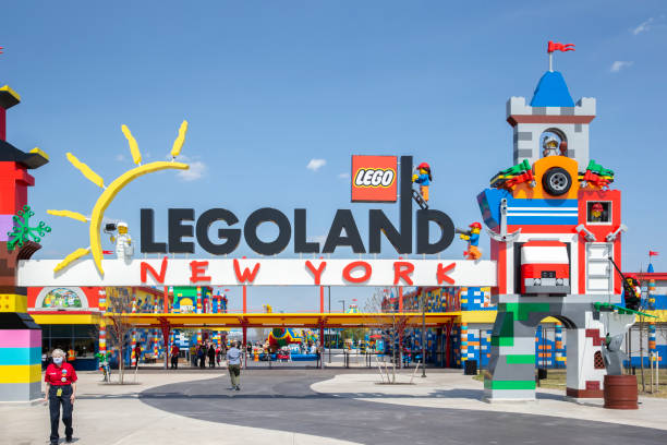 visitors pass through the colorful entrance gate to legoland in new york. lego building blocks - legoland imagens e fotografias de stock