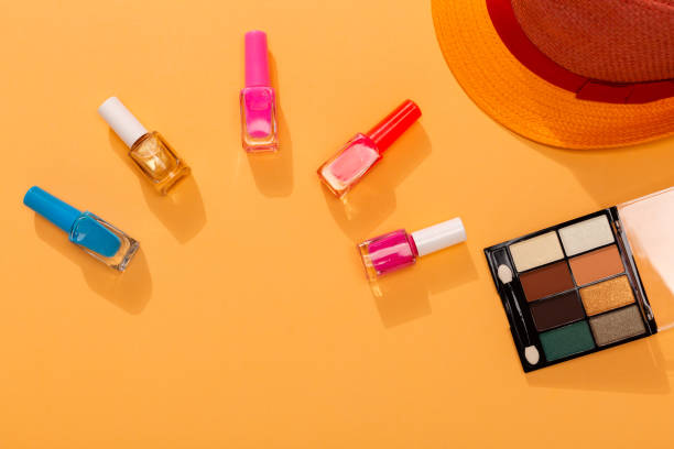 Vivid colors nail polish variation on orange background with sunglasses and hat, as a symbol of summer fashion. stock photo