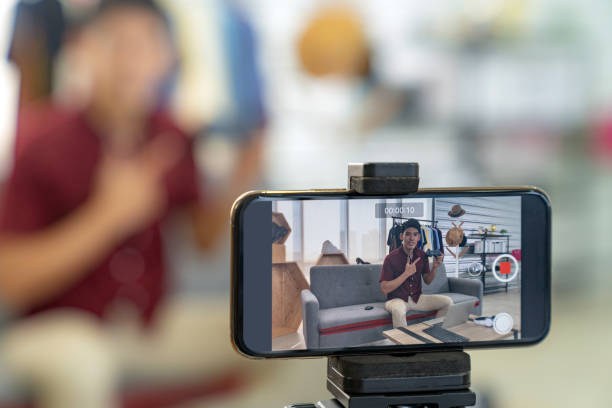 Vlogger live review joystick gaming  product Young asian male online blogger recording live vlog video for review joystick for gaming IT product goods. Online influencer on social media concept. Focus on mobile phone vlogging stock pictures, royalty-free photos & images