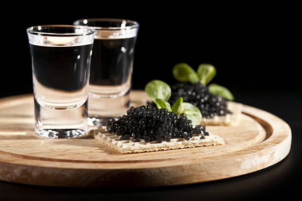 vodka and sandwiches with black caviar served place setting: vodka and sandwiches with black caviar on black background roe stock pictures, royalty-free photos & images
