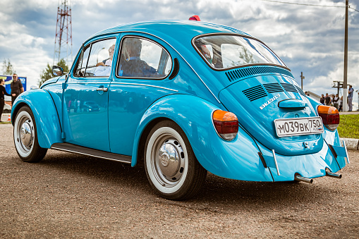 Moscow, Russia - July 06, 2019: Volkswagen KÃ¤fer 1303. Type 1 Vintage VW Beetle was produced since 1946. A blue retro car stands in the parking lot with a driver inside. Back side view