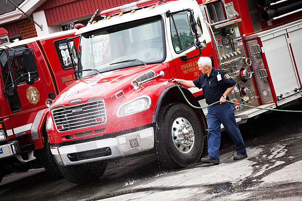 Volunteer Firefighter washing fire truck stock photo