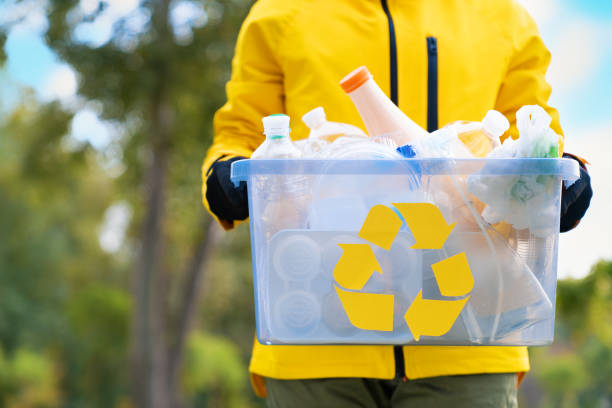Volunteer holding plastic garbage container for recycling stock photo