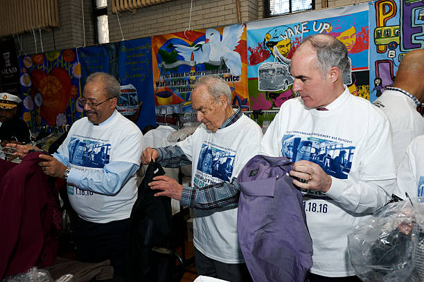 Volunteers Working Together at Martin Luther King Day of Service Philadelphia, PA, USA - January 18, 2016; Congressman Chaka Fattah, former U.S. Sen. Harris Wofford and Senator Bob Casey volunteer at a gently used business attire sorting project during the 21st Martin Luther King Day of Service in Philadelphia, PA. martin luther king jr day stock pictures, royalty-free photos & images