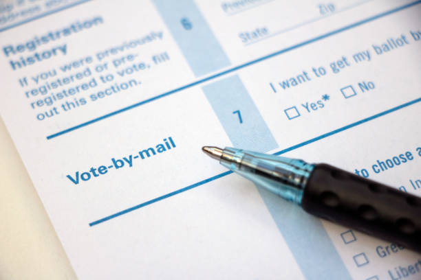 Voter Registration - Vote by Mail with pen Closeup of 'Vote-by-mail' section on a voter registration form, with ballpoint pen laying on the form. voting ballot photos stock pictures, royalty-free photos & images