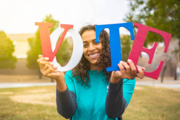 Voting Holding VOTE letters colored in Red, White and Blue. voting rights stock pictures, royalty-free photos & images