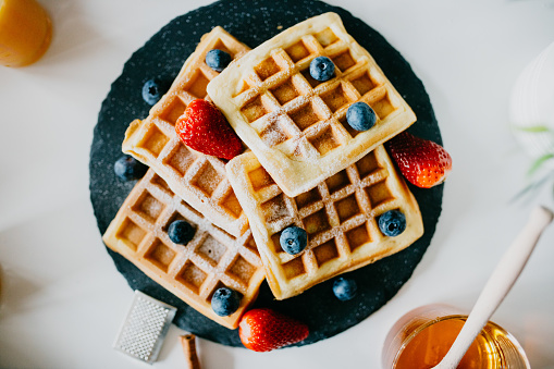 Waffles with blueberries, strawberries and powdered sugar