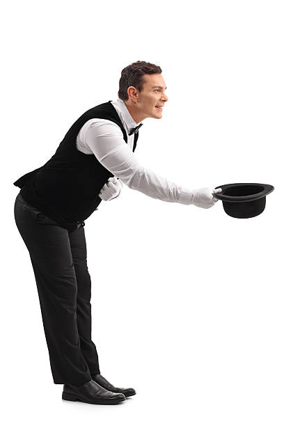 Waiter bow down and taking off his hat Full length profile shot of a young male waiter bow down and taking off his hat isolated on white background hats off to you stock pictures, royalty-free photos & images