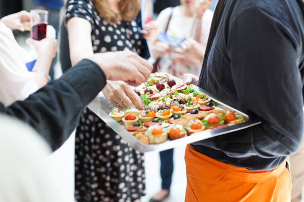 waiter doing catering service at social gathering catering service at social gathering canape photos stock pictures, royalty-free photos & images