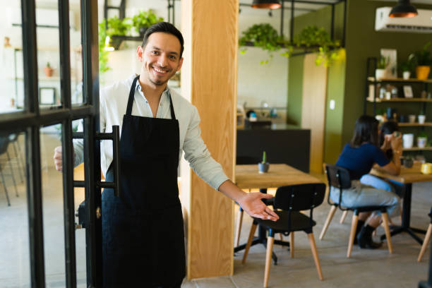 Waiter inviting people in at a restaurant stock photo