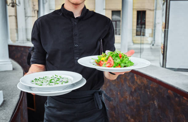 Waiters carrying plates with food, in a restaurant. stock photo