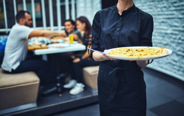 Waiters carrying plates with food, in a restaurant. stock photo