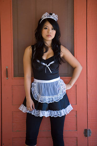 Waiting by the Door A French Maid is waiting in front of an old red wooden door. french maid outfit stock pictures, royalty-free photos & images