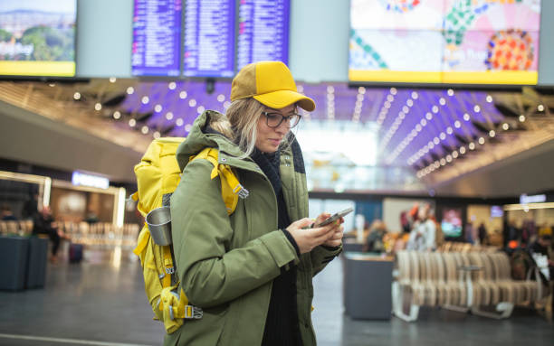 Waiting for the plane and going on vacation, the mountaineer uses a mobile phone. ISL stock photo