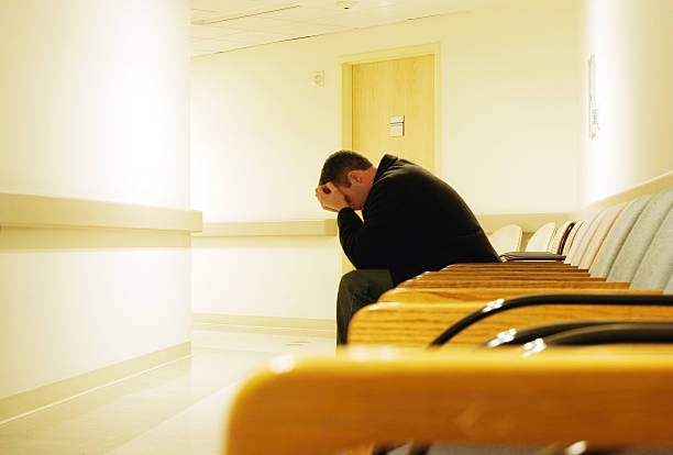 Waiting Room "Man sits alone, worried and waiting for his destiny to unfold." mourner stock pictures, royalty-free photos & images
