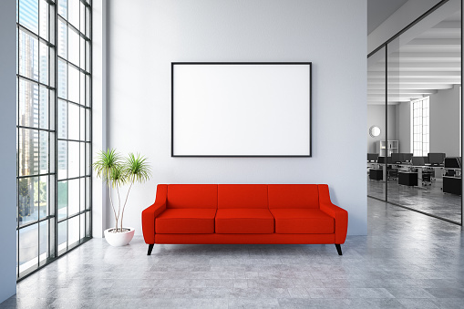 Waiting room with empty picture frame and red sofa