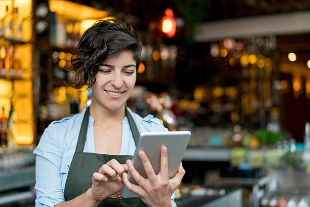 Waitress using a tablet computer Happy waitress working at a restaurant and using app on a digital tablet waiter taking order stock pictures, royalty-free photos & images