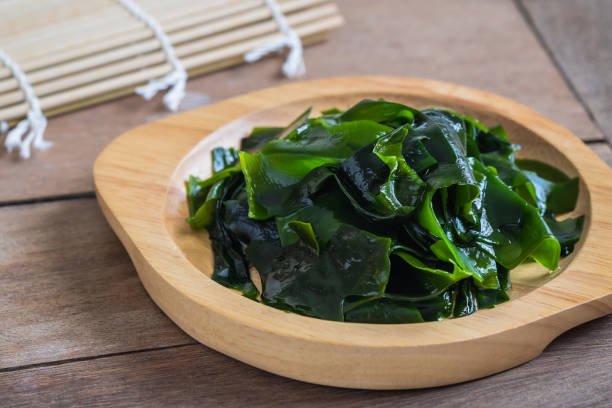 Wakame seaweed on wooden plate Wakame seaweed on wooden plate seaweed stock pictures, royalty-free photos & images