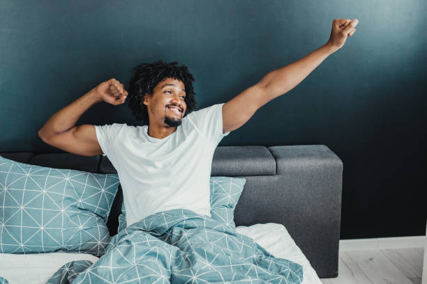 Waking up with a smile Young man in the morning waking up and stretching waking up stock pictures, royalty-free photos & images