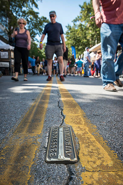 Walk the line - Bristol, TN/VA Bristol, Tennessee, USA - September 20, 2014: Crowds gather in downtown Bristol for the 2014 Rhythm and Roots Festival. The town is bisected by the Tennessee-Virginia state line and is known as the birthplace of country music. virginia us state stock pictures, royalty-free photos & images