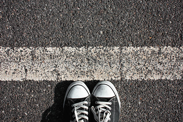 Walking obstacle People shoes standing on the asphalt with white line. boundary stock pictures, royalty-free photos & images