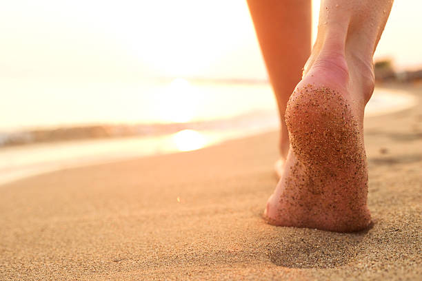 walking on the beach. - voeten in het zand stockfoto's en -beelden