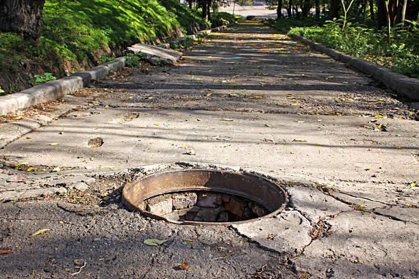 Walkway with opened sewers hatch stock photo
