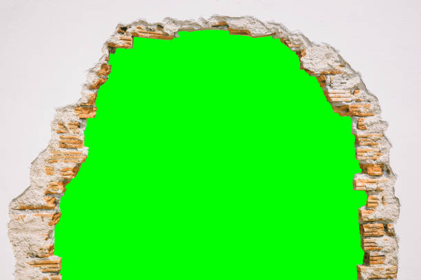 wall break through with green screen background. stock photo